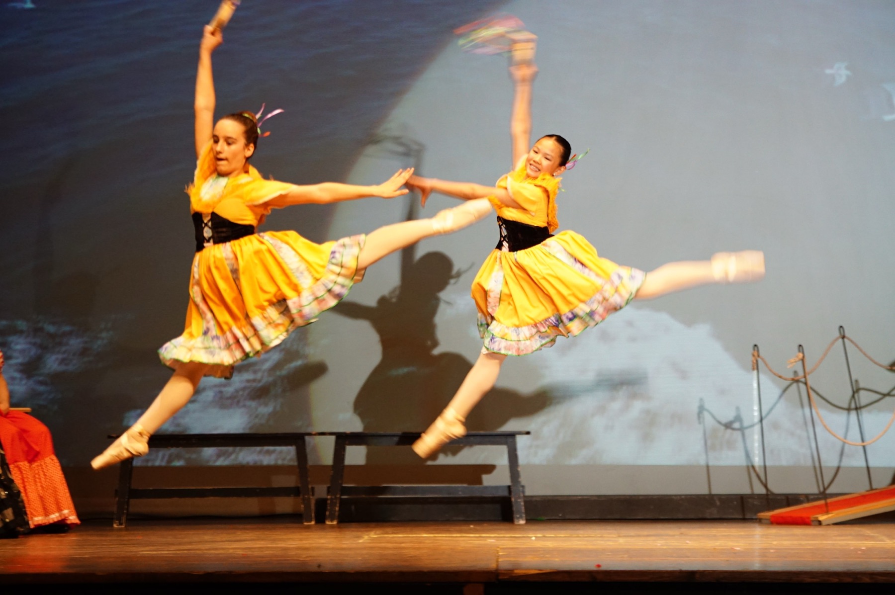 Dues ballarines saltant amb vestits grocs
